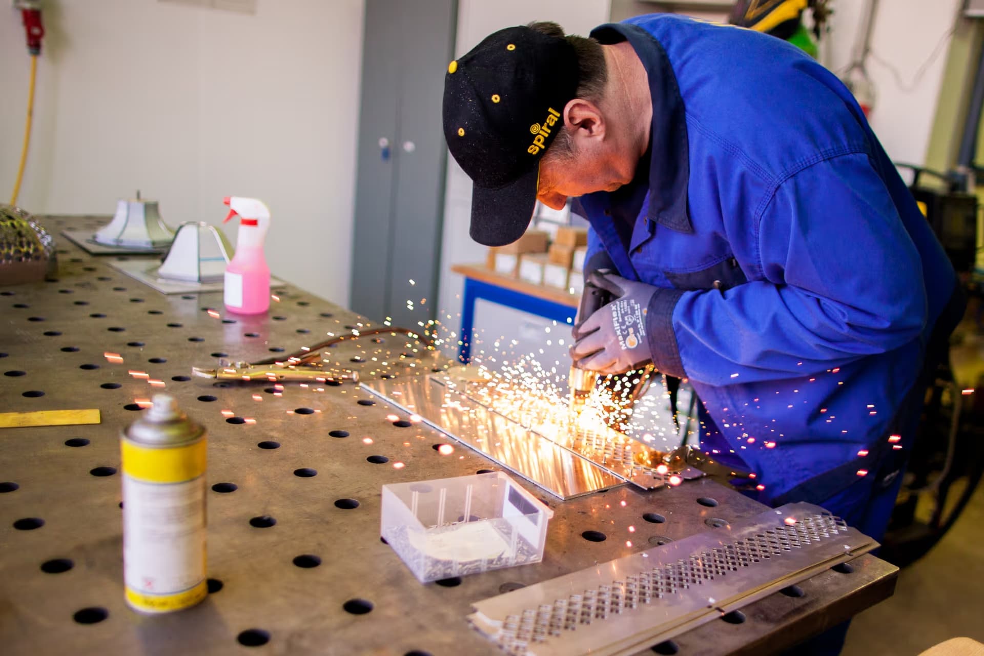 metalworker grinding sheet metal by hand, showcasing handcrafted craftsmanship