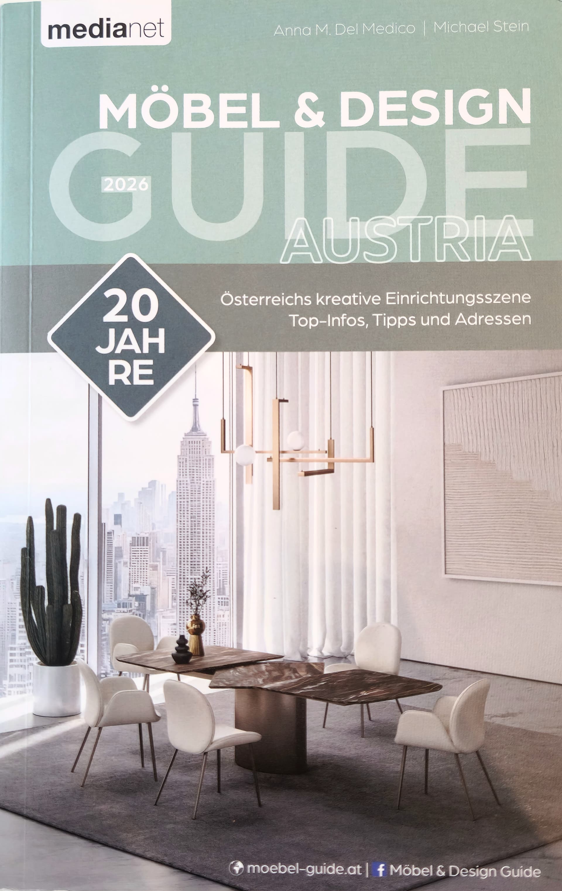 Cover of the Furniture & Design Guide Austria featuring a modern dining room with interior with chandelier and city view