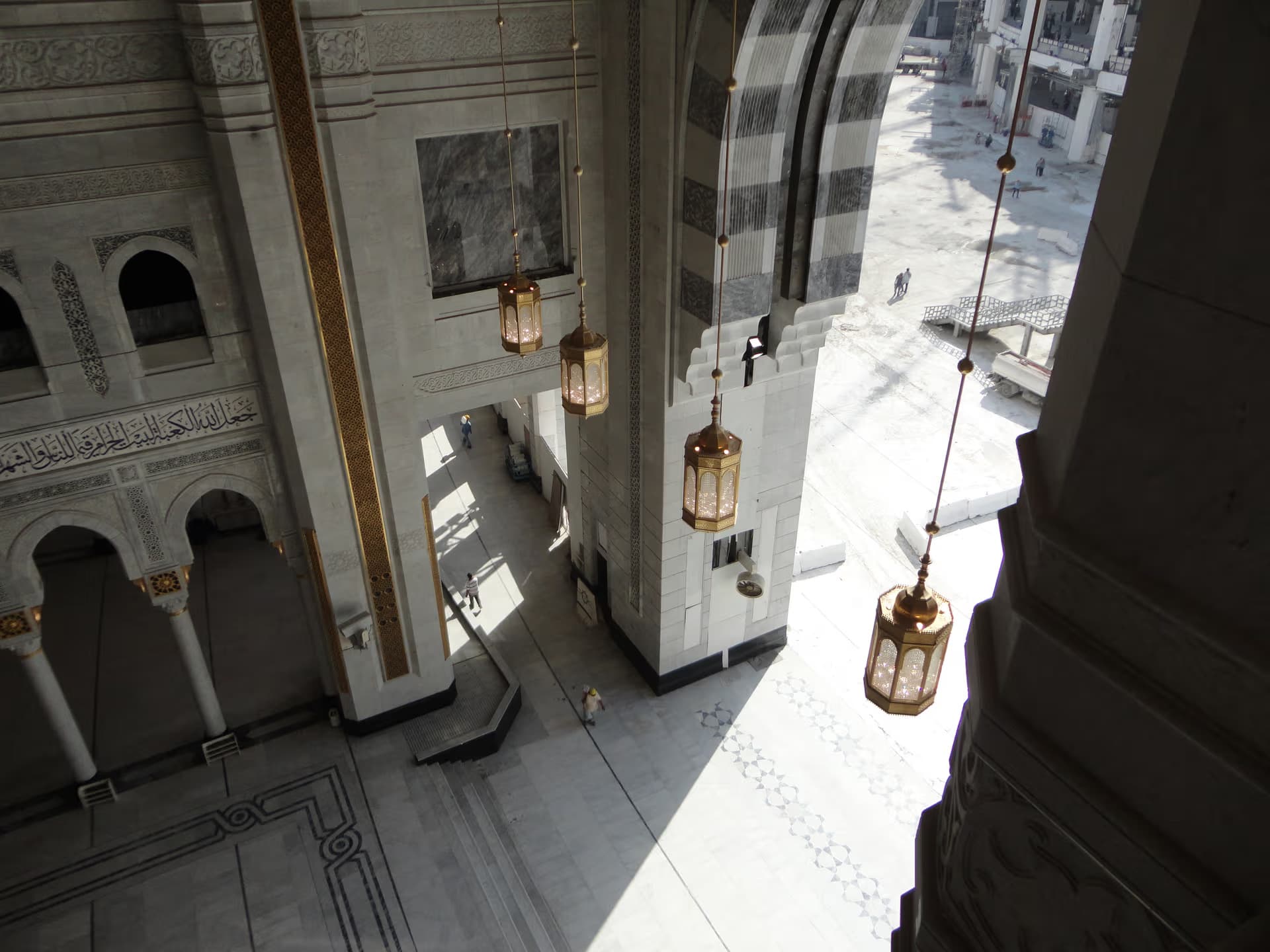 Architectural view of the Holy Mosque entrance in Makkah with marble columns, ornate arches and golden details
